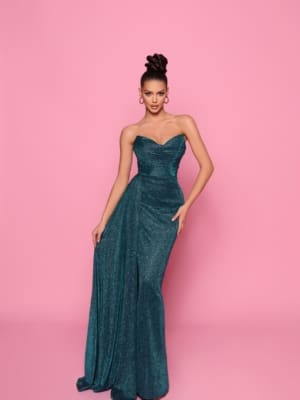 A woman wearing the elegant IZY NP149 teal strapless floor-length gown poses against a pink background. Her hair is styled in an updo, and she accessorizes with hoop earrings. The vibrant setting echoes the sunny vibes of Queensland’s Sunshine Coast. Angels Formal Wear