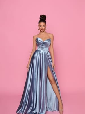 A woman is posing against a pink background, confidently showcasing the LA BELLA NP158 gown. This strapless, blue metallic dress features a sweetheart neckline and a high slit on one side, stylishly revealing part of her leg. Ideal for Race Day or Cocktail Dresses events at the Sunshine Coast, she complements her look with an elegant updo hairstyle, hoop earrings, and open-toe heels. Angels Formal Wear