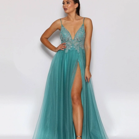 A woman stands confidently in a long, teal gown with a deep V-neckline and intricate embellishments on the bodice. The HARMONY JX2099, available at Dress Shop Sunshine Coast, features a high slit revealing one leg. She has her hair pulled back and is posing against a plain white background. Angels Formal Wear